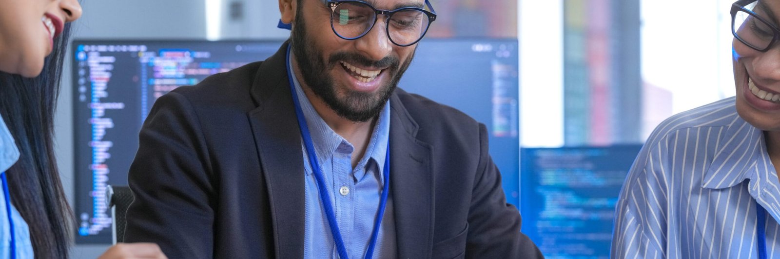A diverse creative team brainstorms ideas in a meeting, using tablets for collaboration. Smiling professionals discuss a new UI/UX design for an app in a modern office.